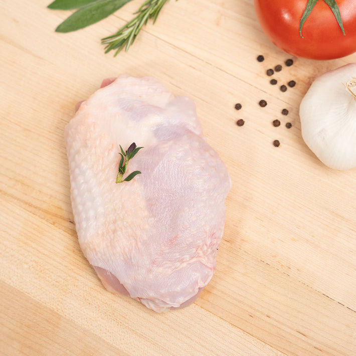 A Joyce Farms Poulet Rouge® Heritage Boneless, Skin-On Whole Chicken Legs is sitting on top of a wooden table.