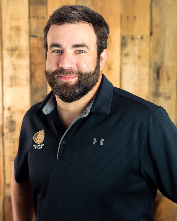 Image - headshot of Ryan Joyce, Joyce Farms' President & CEO, smiling in black shirt with Joyce Farms logo