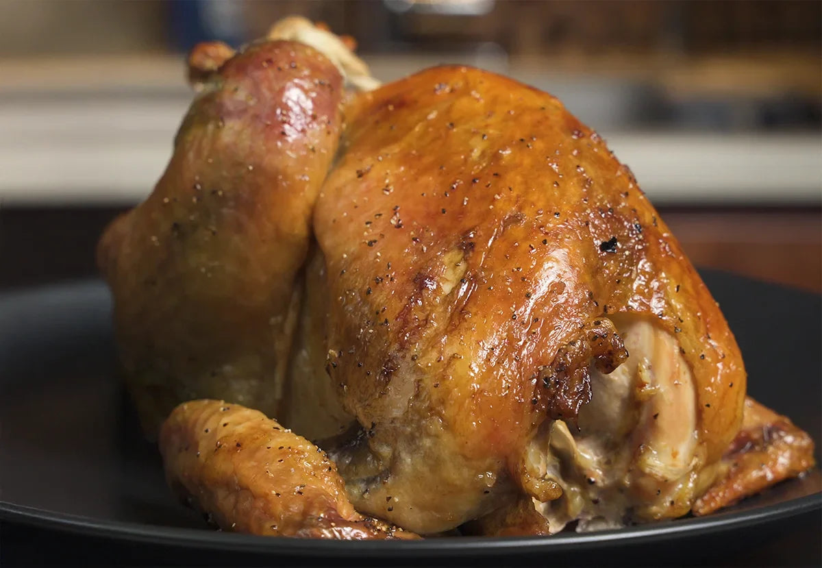 Roasted Joyce Farms Heritage Pintade on a plate, ready to carve.