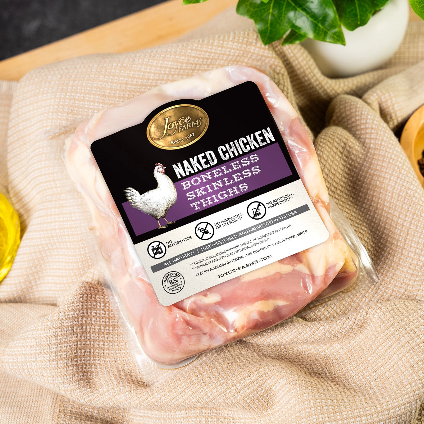 Packaged chicken thighs with a label resting on a kitchen towel