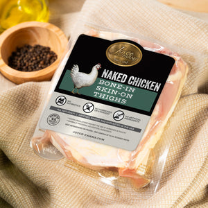 Packaged Naked Chicken on a textured fabric background with a bowl of spices.