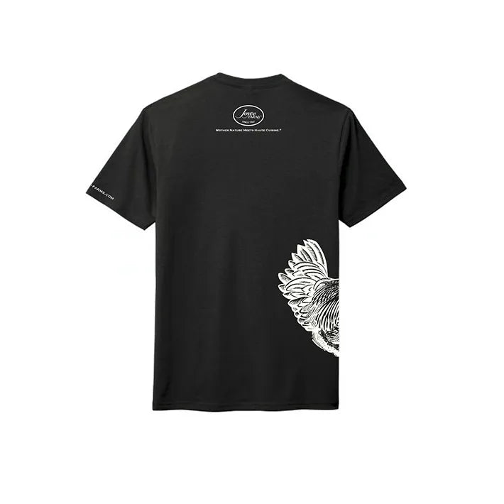 Back view of a black t-shirt featuring the Joyce Farms logo centered near the top. The shirt also displays a detailed white line illustration of a Joyce Farms Poulet Rouge® Heritage chicken, with the tail feathers extending from the bottom right side.