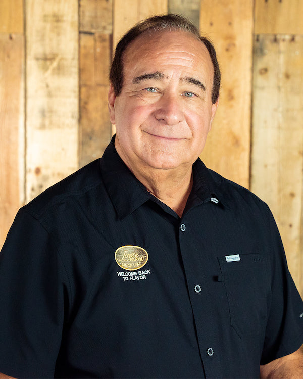 Image - headshot of Ron Joyce, Joyce Farms' Chairman of the Board, smiling in black shirt with Joyce Farms logo
