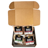 An open black box containing a savory variety pack of Joyce Farms Naked Chicken Sausages, made from antibiotic-free chicken. The pack includes four flavors: Sundried Tomato, Chipotle, Mild Italian, and Spinach & Feta. Each package of sausage is clearly labeled with its flavor.